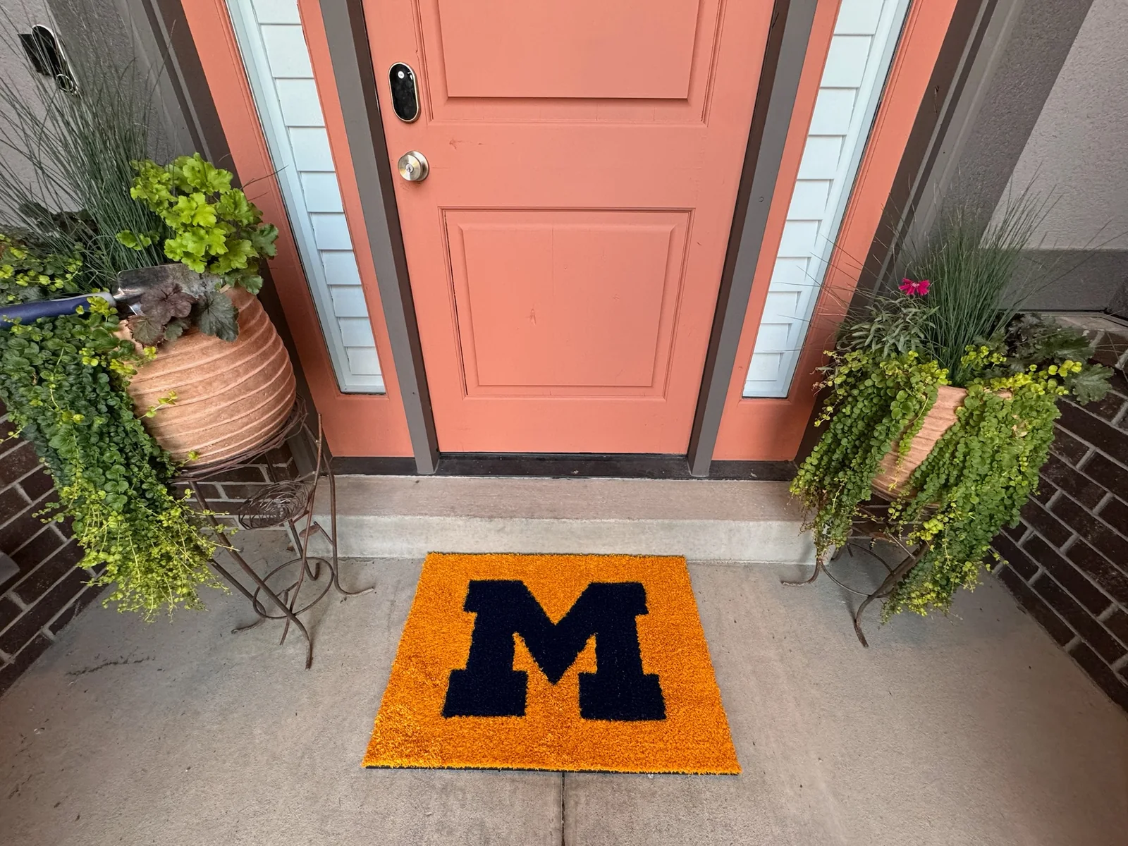 Maize-and-navy Michigan turf doormat outside a front door